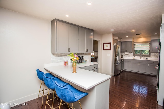 4609 10th St, Lubbock, TX 79416 - kitchen featuring gray cabinets, stainless steel fridge, a sink, backsplash, and recessed lighting