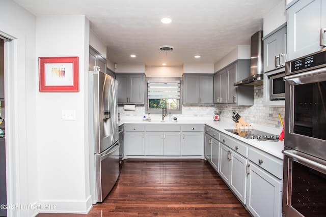 4609 10th St, Lubbock, TX 79416 - kitchen with stainless steel appliances, gray cabinets, wall chimney exhaust hood, backsplash, and dark wood-type flooring
