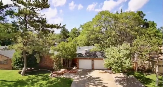3806 56th St, Lubbock, TX 79413 - obstructed view of property with concrete driveway, an attached garage, and a front lawn