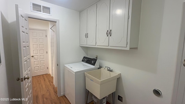 3806 56th St, Lubbock, TX 79413 - laundry room with washer / clothes dryer, cabinet space, and light wood-type flooring