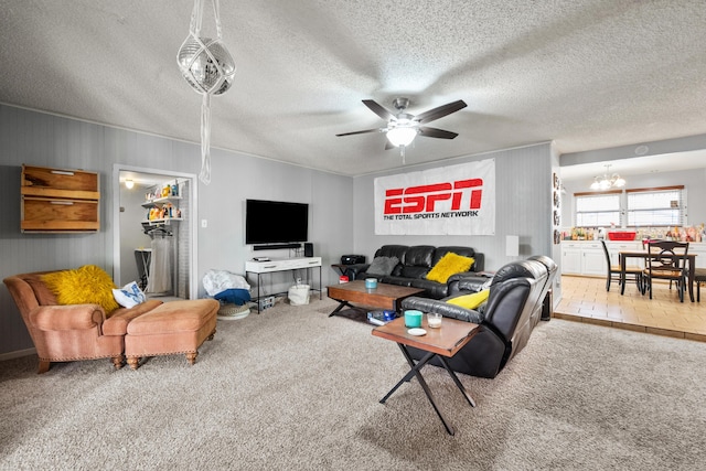 carpeted living room with a textured ceiling and ceiling fan with notable chandelier