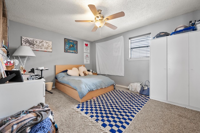 carpeted bedroom featuring ceiling fan and a textured ceiling