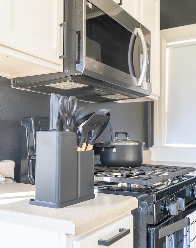 kitchen with white cabinetry and black range with gas stovetop