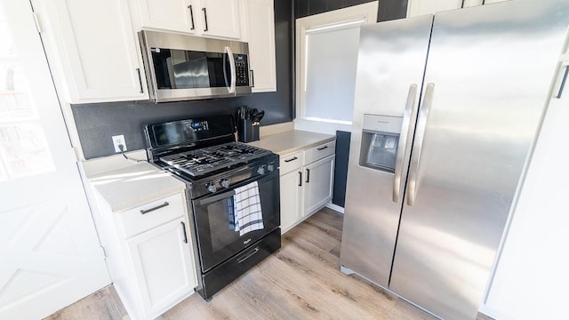 kitchen featuring stainless steel appliances, light hardwood / wood-style floors, and white cabinets