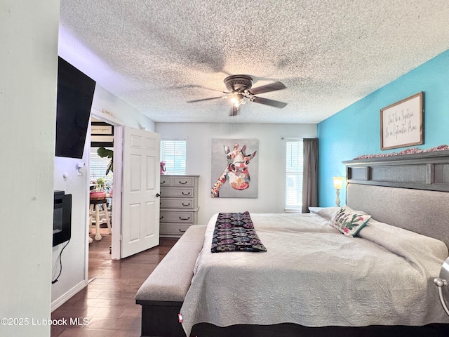 5623 87th St, Lubbock, TX 79424 - bedroom featuring multiple windows, wood finished floors, a textured ceiling, and ceiling fan