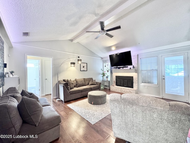 5623 87th St, Lubbock, TX 79424 - living room featuring a textured ceiling, a ceiling fan, wood finished floors, and a fireplace