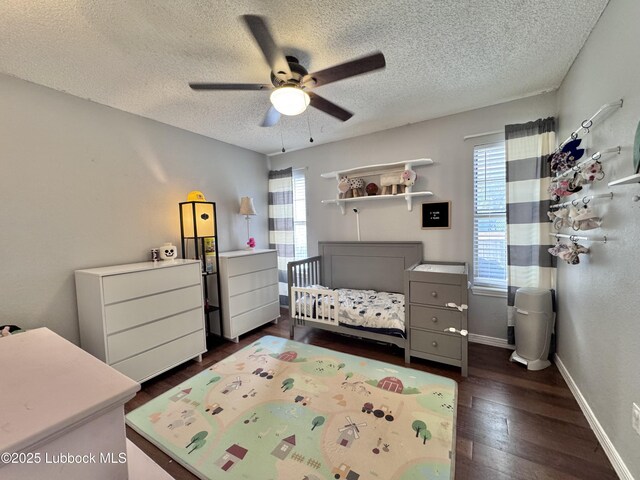 5623 87th St, Lubbock, TX 79424 - bedroom featuring multiple windows, a textured ceiling, dark wood-style flooring, baseboards, and a ceiling fan