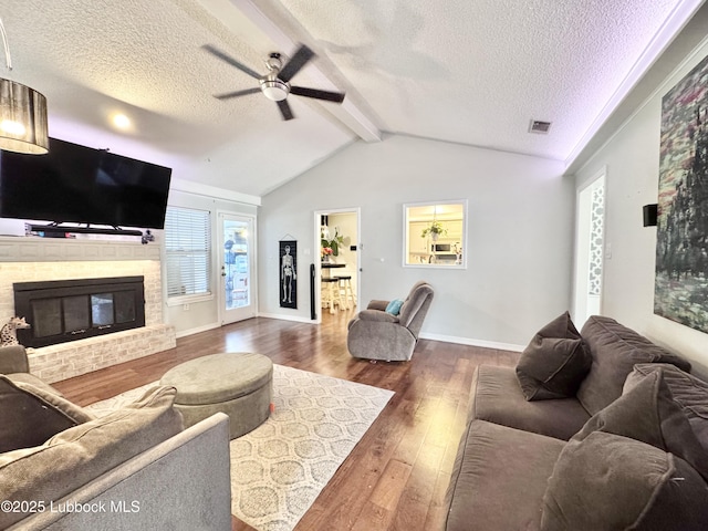 5623 87th St, Lubbock, TX 79424 - living room with a ceiling fan, a textured ceiling, dark wood finished floors, a brick fireplace, and baseboards