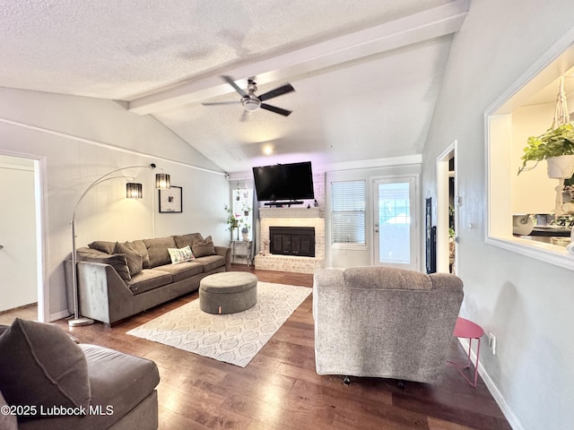 5623 87th St, Lubbock, TX 79424 - living room with wood finished floors, ceiling fan, a brick fireplace, a textured ceiling, and baseboards