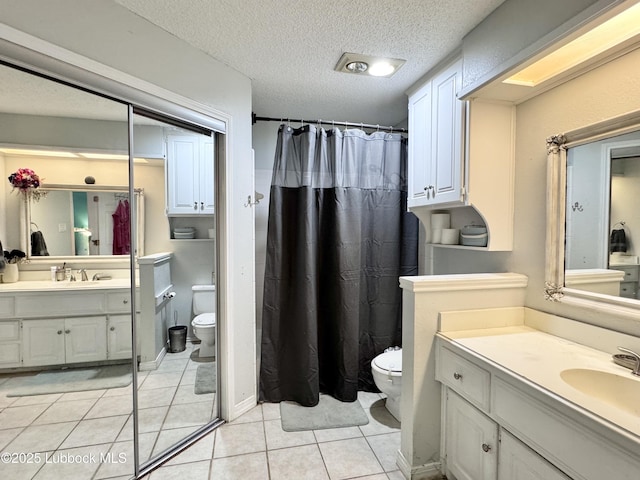 5623 87th St, Lubbock, TX 79424 - bathroom with toilet, vanity, tile patterned flooring, a textured ceiling, and a shower with shower curtain
