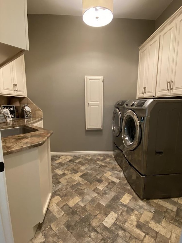 laundry room with cabinets, sink, and washing machine and dryer