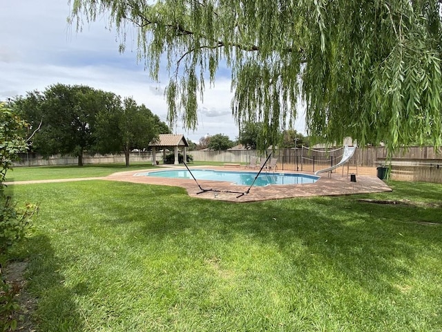 view of pool with a gazebo, a water slide, and a lawn