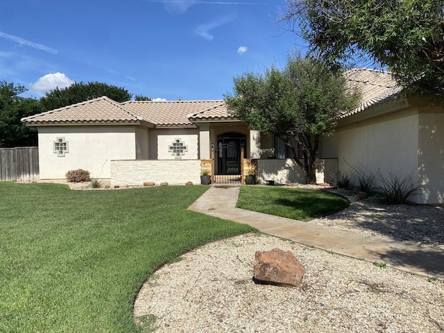 mediterranean / spanish home with a front yard