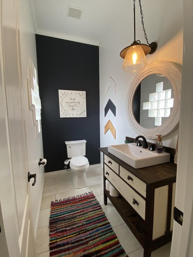 bathroom featuring tile patterned flooring, ornamental molding, vanity, and toilet