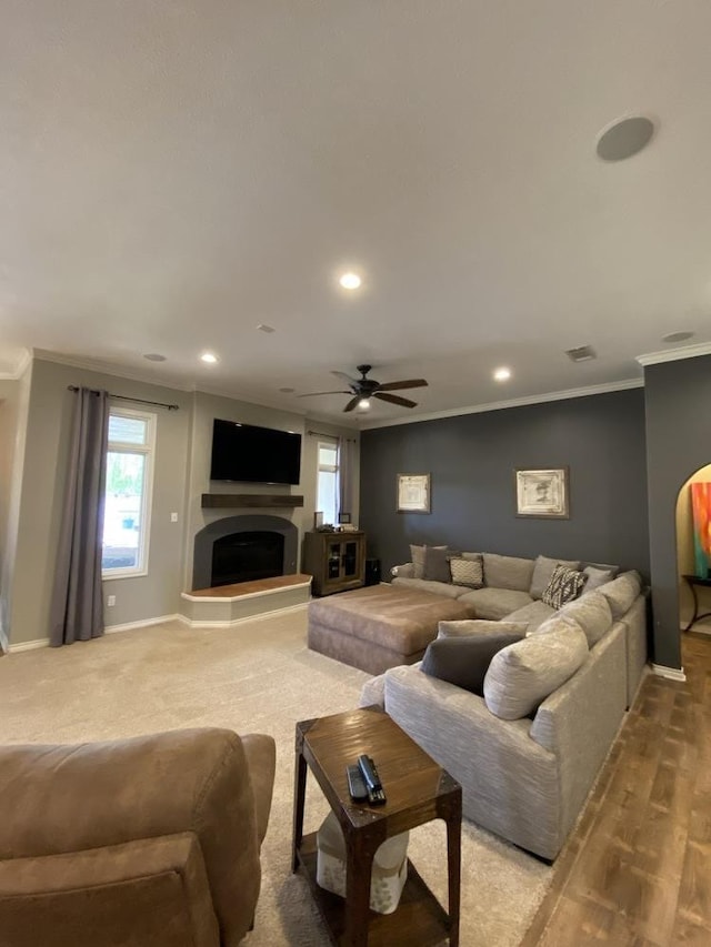 living room featuring a wealth of natural light, ornamental molding, and ceiling fan