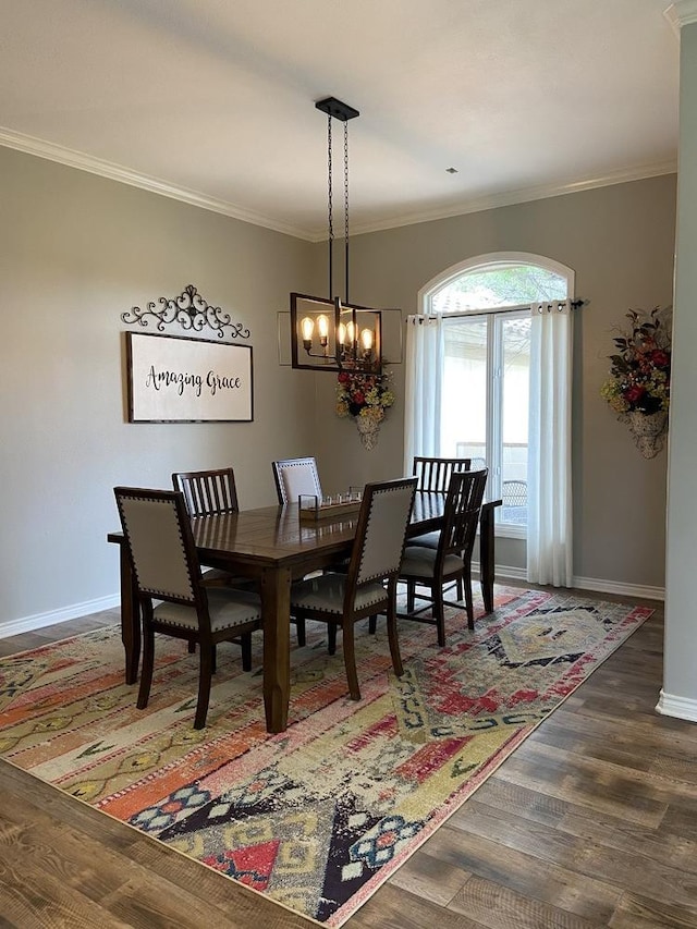 dining room featuring crown molding, dark wood-type flooring, and a chandelier