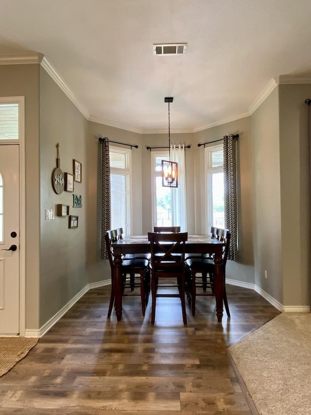 dining room with ornamental molding and dark hardwood / wood-style flooring