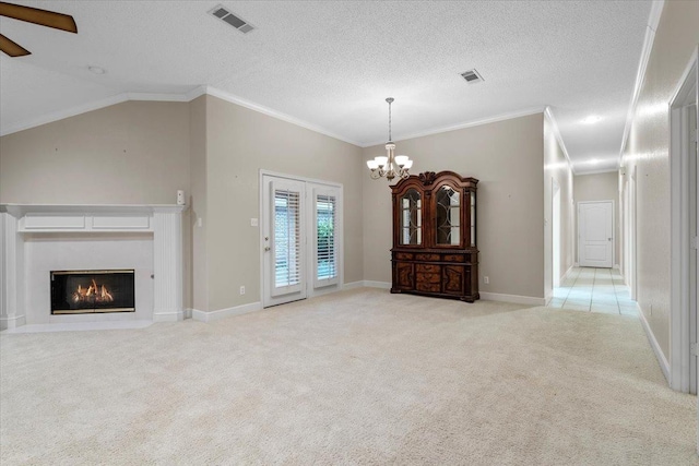 unfurnished living room with lofted ceiling, ornamental molding, a textured ceiling, ceiling fan with notable chandelier, and light colored carpet