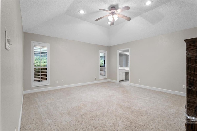 unfurnished room with ceiling fan, a textured ceiling, light colored carpet, and a healthy amount of sunlight