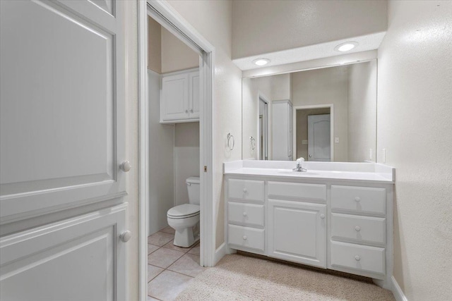 bathroom featuring vanity, tile patterned floors, and toilet