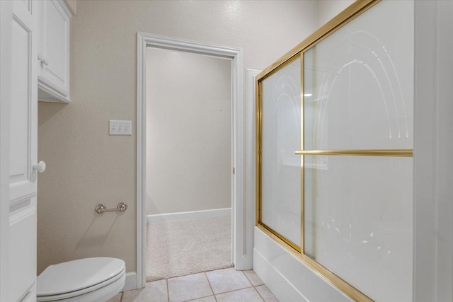 bathroom featuring tile patterned floors, enclosed tub / shower combo, and toilet