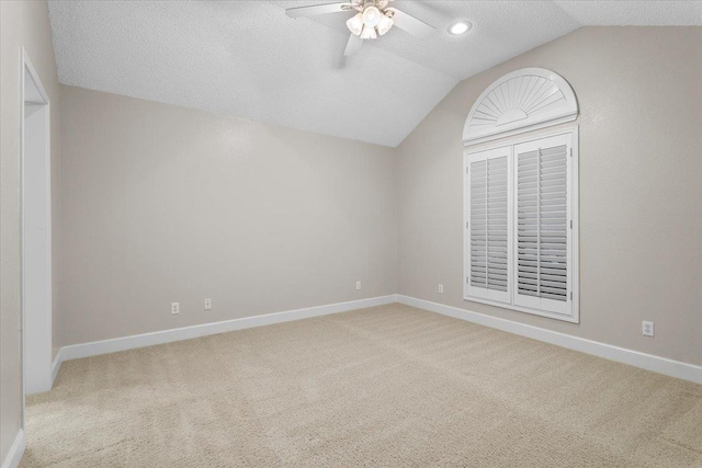 interior space featuring ceiling fan, lofted ceiling, and a textured ceiling