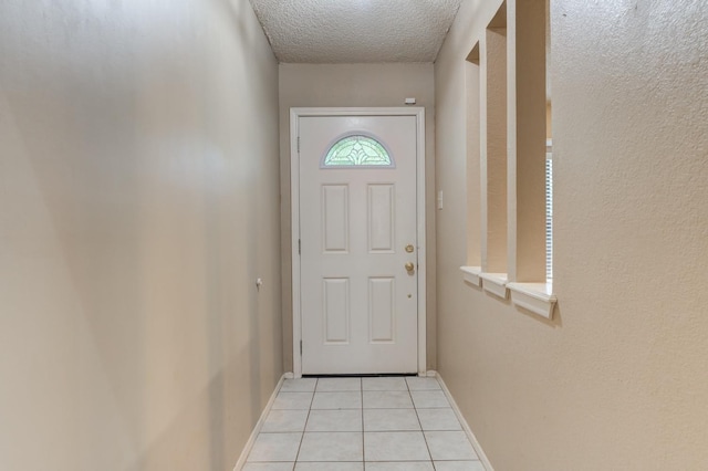 doorway featuring light tile patterned floors and a textured ceiling