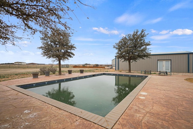 view of swimming pool with a patio and french doors