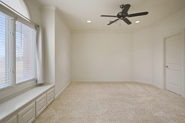 unfurnished room featuring crown molding, light colored carpet, and ceiling fan