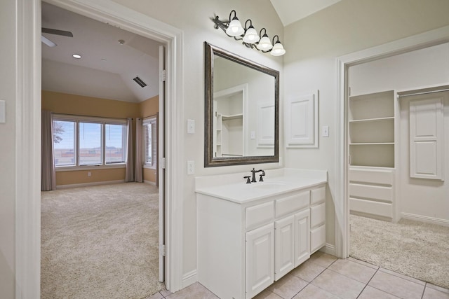 bathroom featuring ceiling fan, vanity, tile patterned flooring, and vaulted ceiling