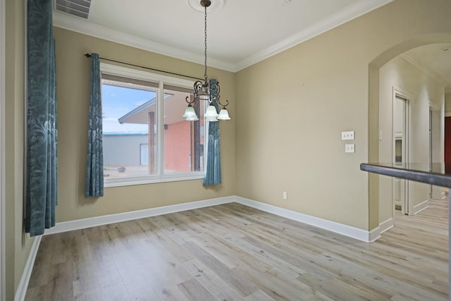 unfurnished dining area featuring crown molding, light hardwood / wood-style flooring, and a chandelier