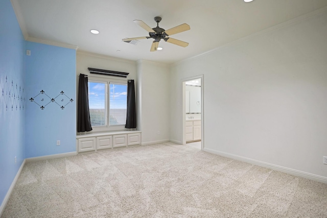 empty room featuring crown molding, light carpet, and ceiling fan