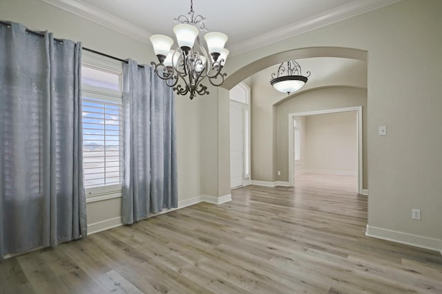 unfurnished dining area featuring crown molding, a chandelier, and light hardwood / wood-style floors