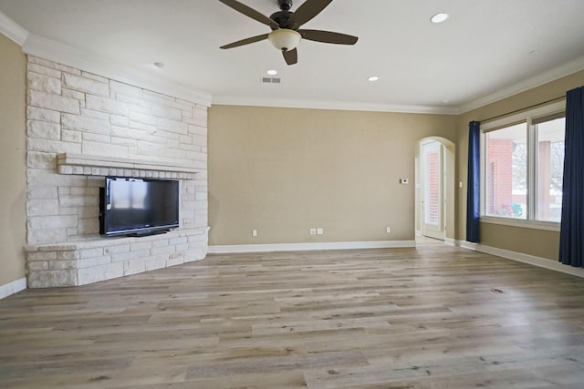 unfurnished living room featuring a fireplace, ornamental molding, light hardwood / wood-style floors, and ceiling fan