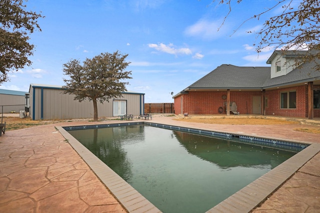 view of pool featuring a patio area and a storage shed