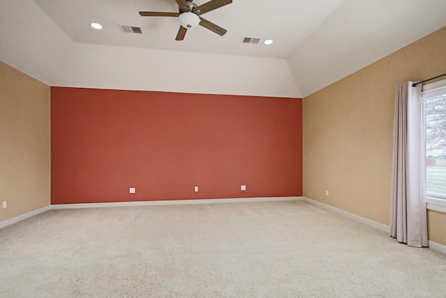 empty room with lofted ceiling, light colored carpet, and ceiling fan