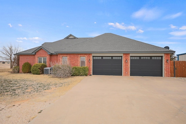 ranch-style house with a garage and cooling unit