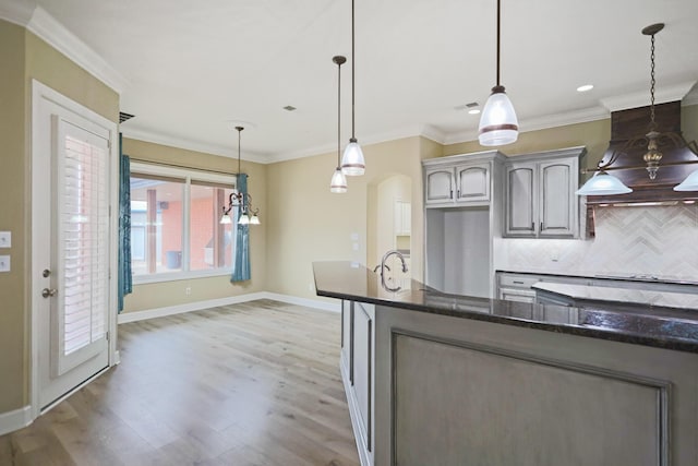 kitchen with tasteful backsplash, crown molding, and pendant lighting