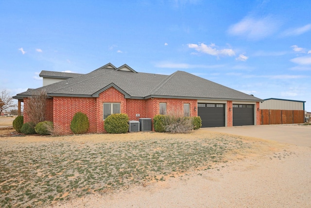 single story home with a garage and central AC unit