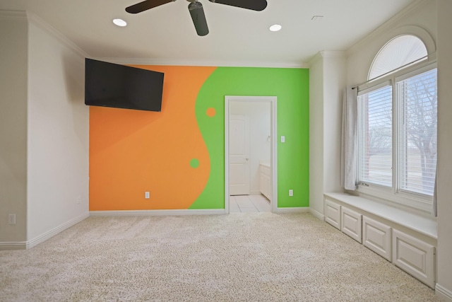 unfurnished bedroom featuring crown molding, ensuite bath, ceiling fan, and light carpet