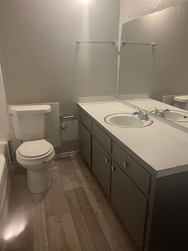 bathroom with vanity, hardwood / wood-style floors, and toilet