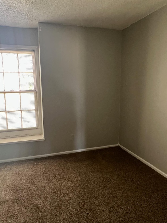 carpeted empty room with a textured ceiling