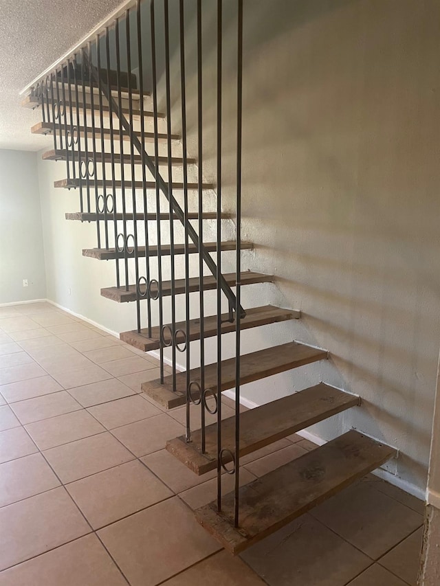 staircase featuring tile patterned floors and a textured ceiling