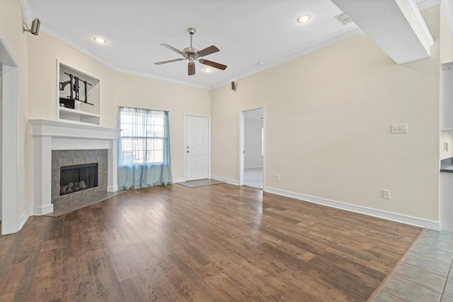 unfurnished living room featuring ornamental molding, wood-type flooring, ceiling fan, and a fireplace