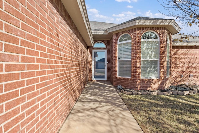 view of exterior entry with a lawn