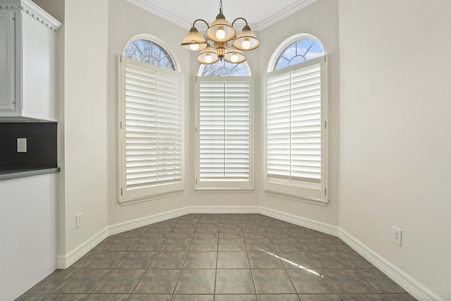 unfurnished dining area with dark tile patterned flooring, a notable chandelier, and ornamental molding