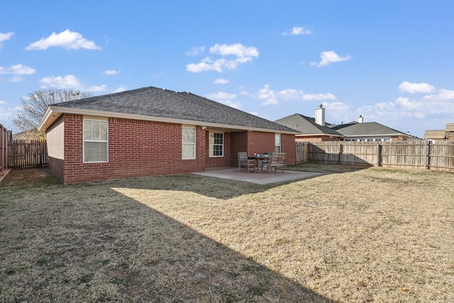 rear view of house featuring a yard and a patio area