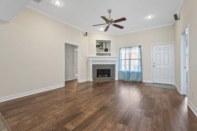 unfurnished living room with crown molding, ceiling fan, dark hardwood / wood-style flooring, and a tiled fireplace