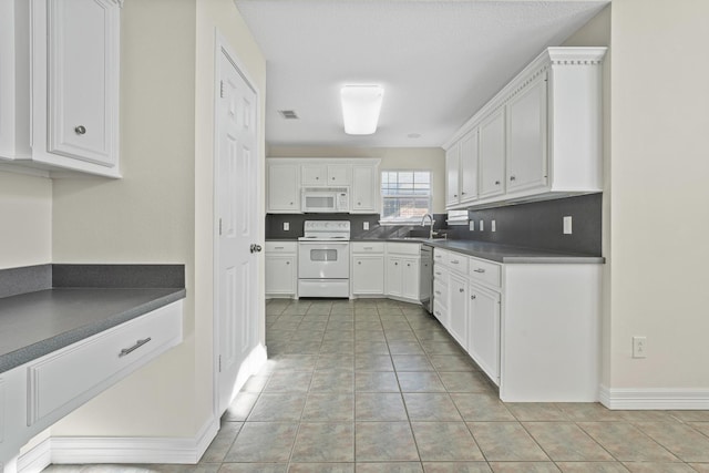 kitchen with white cabinetry, sink, decorative backsplash, light tile patterned floors, and white appliances