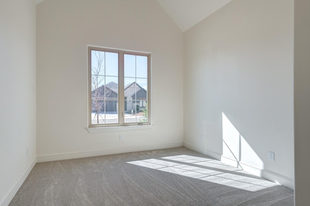 spare room with light colored carpet and high vaulted ceiling